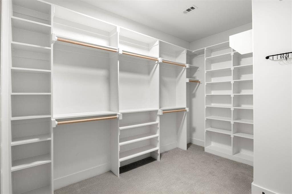 1220 Lynn Way, Waxahachie, TX 75165 Spacious primary closet with extensive built-in shelving, hanging space and direct laundry access.
