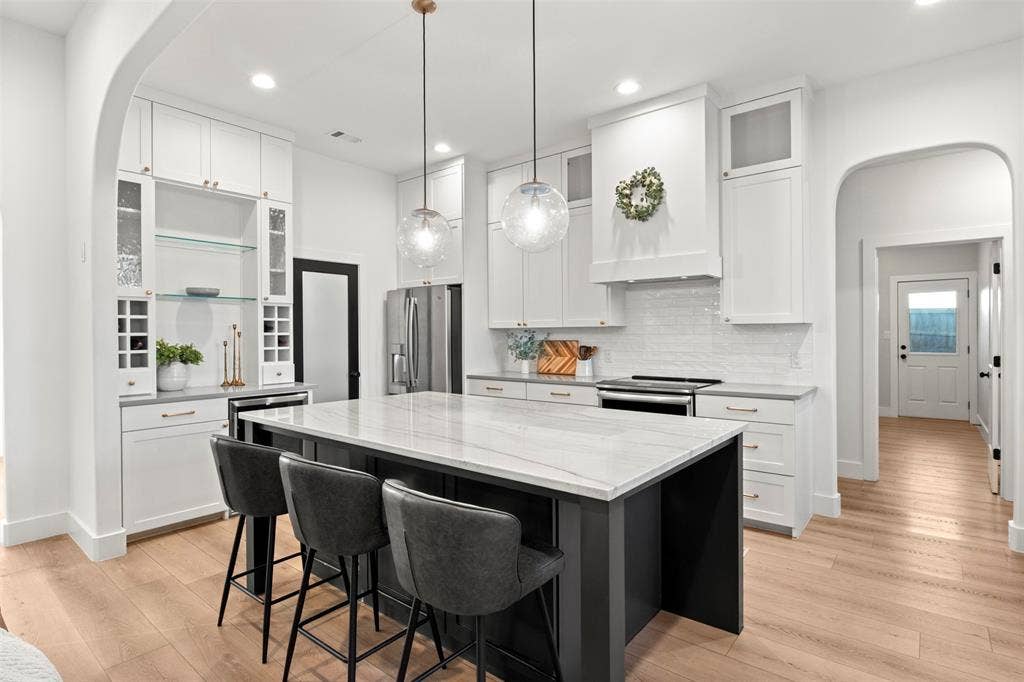 1220 Lynn Way, Waxahachie, TX 75165 Ceiling-height cabinetry, warm brass accents and an oversized island create a standout kitchen.