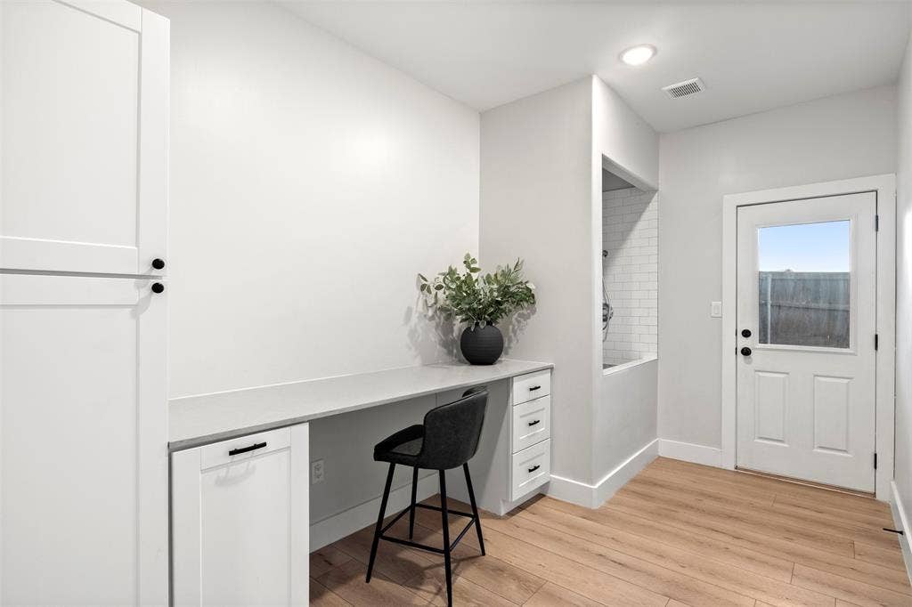 1220 Lynn Way, Waxahachie, TX 75165 Built-in counter and cabinetry provide a convenient everyday workspace. Peep the wash station by the door.