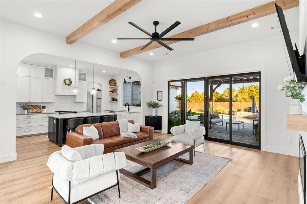 1220 Lynn Way, Waxahachie, TX 75165 Natural wood ceiling beams, warm wide-plank flooring and expansive glass doors set the tone for the home.