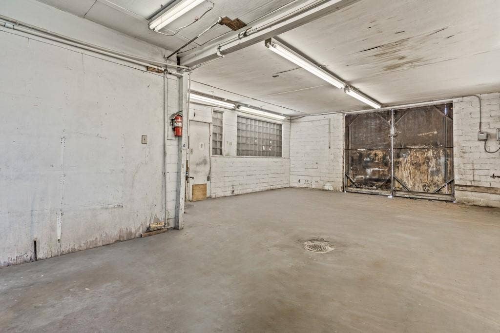 414 E Marshall Street, Gilmer, TX 75644 Concrete flooring with exposed brick walls, industrial ceiling lighting, and large metal doors