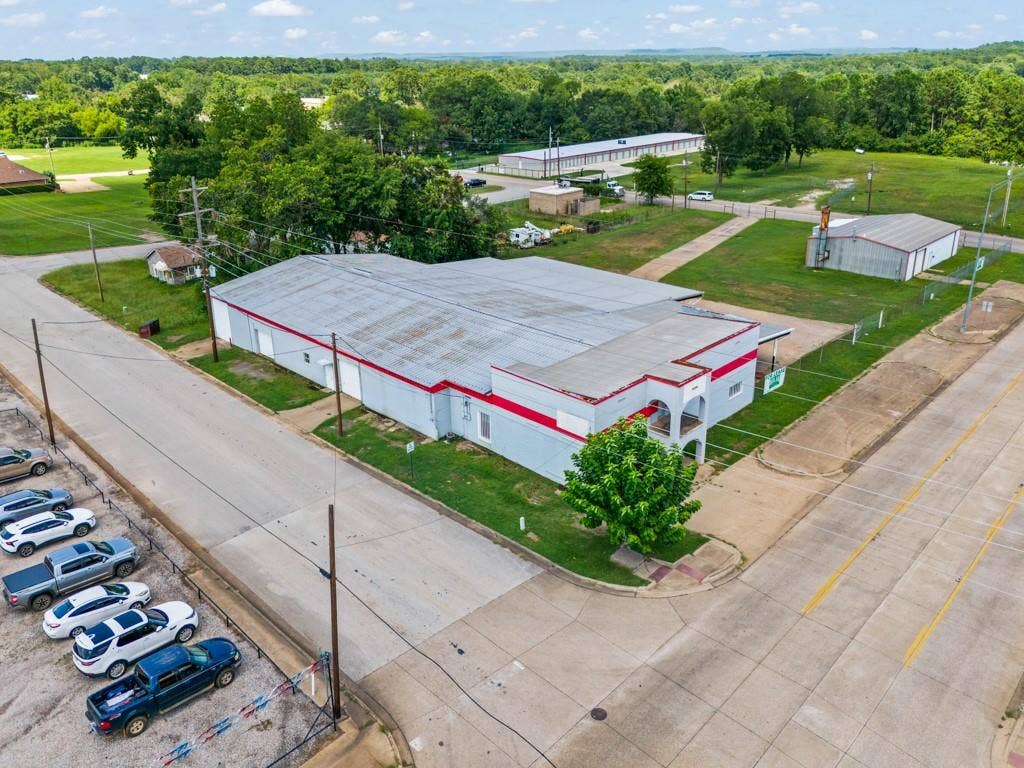 414 E Marshall Street, Gilmer, TX 75644 Commercial building featuring a light gray exterior with red trim