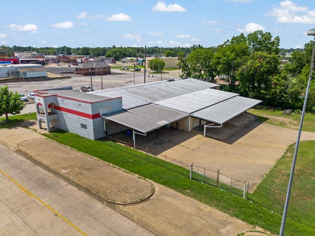414 E Marshall Street, Gilmer, TX 75644 Building with a multi-level facade, red stripe accent, and multiple covered areas