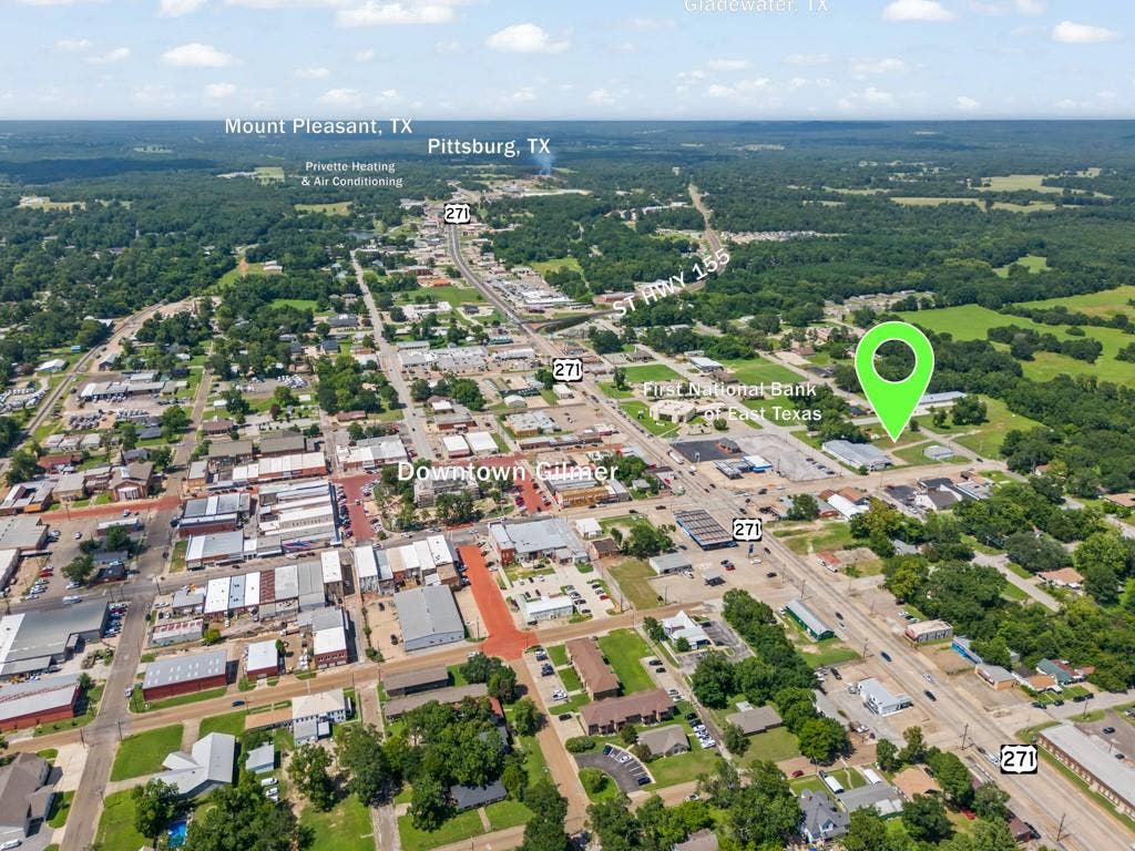 414 E Marshall Street, Gilmer, TX 75644 Aerial perspective of a developed area featuring a major roadway and surrounding commercial and residential structures