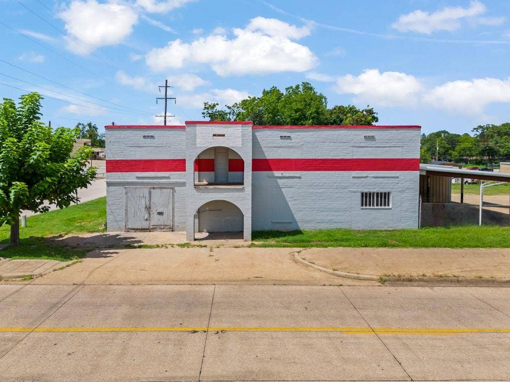 414 E Marshall Street, Gilmer, TX 75644 Single-story commercial building with a light gray and red painted brick exterior