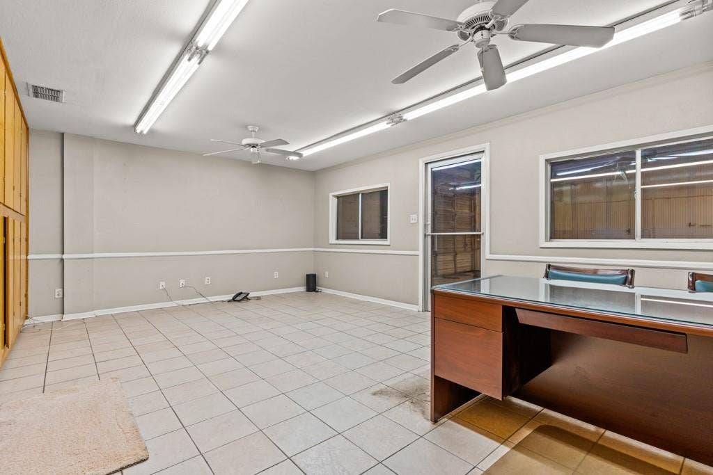 414 E Marshall Street, Gilmer, TX 75644 Tile flooring, built-in wooden cabinetry, multiple windows, fluorescent lighting, and ceiling fans