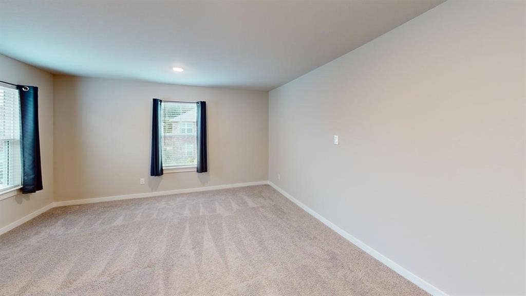 Neutral wall color, recessed lighting, and soft carpet flooring