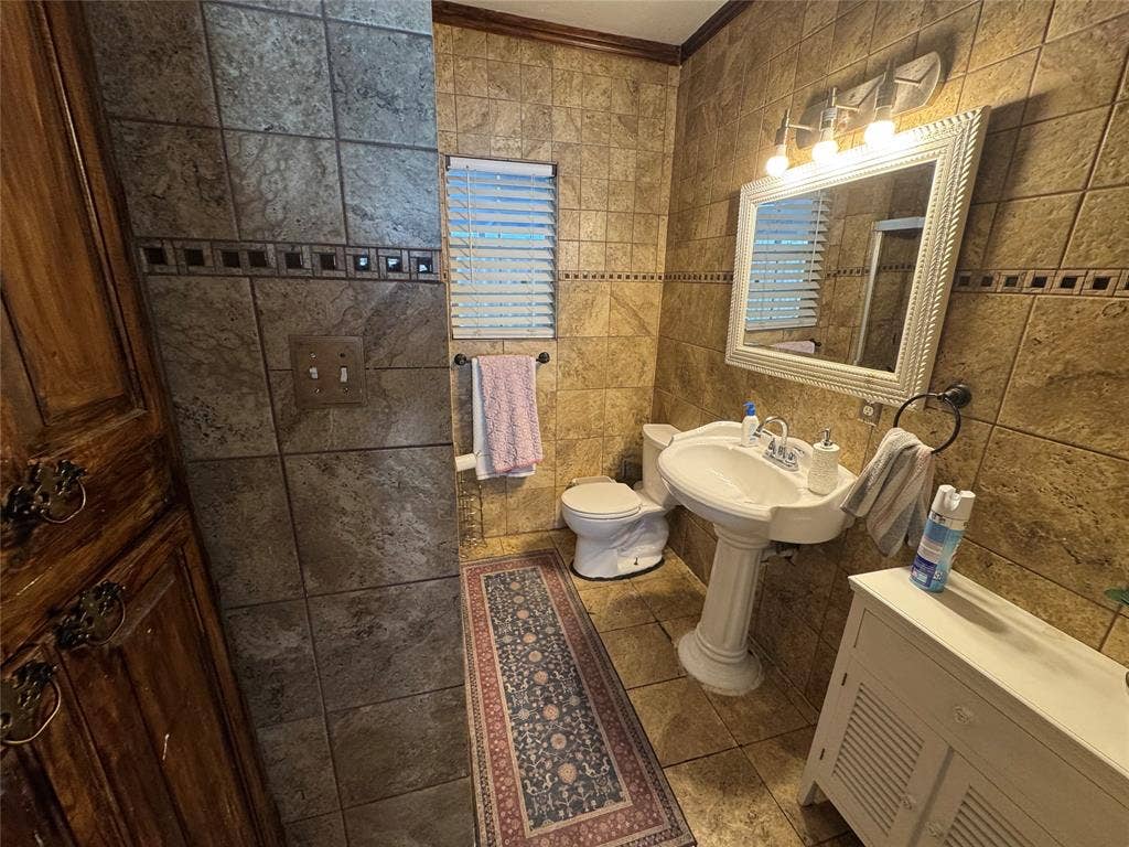 407 S Garrett Avenue, Dallas, TX 75223 Full bathroom with tile walls, tile patterned flooring, a shower, and ornamental molding