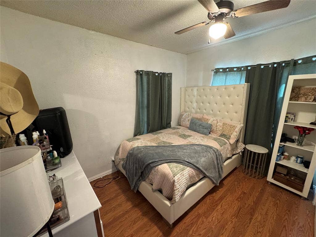 407 S Garrett Avenue, Dallas, TX 75223 Bedroom with a textured ceiling, wood finished floors, ceiling fan, and a textured wall