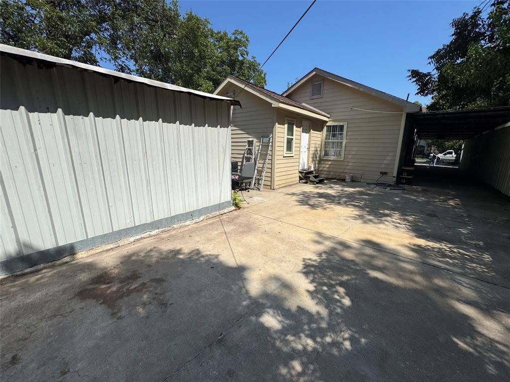 407 S Garrett Avenue, Dallas, TX 75223 View of property exterior with a carport and concrete driveway