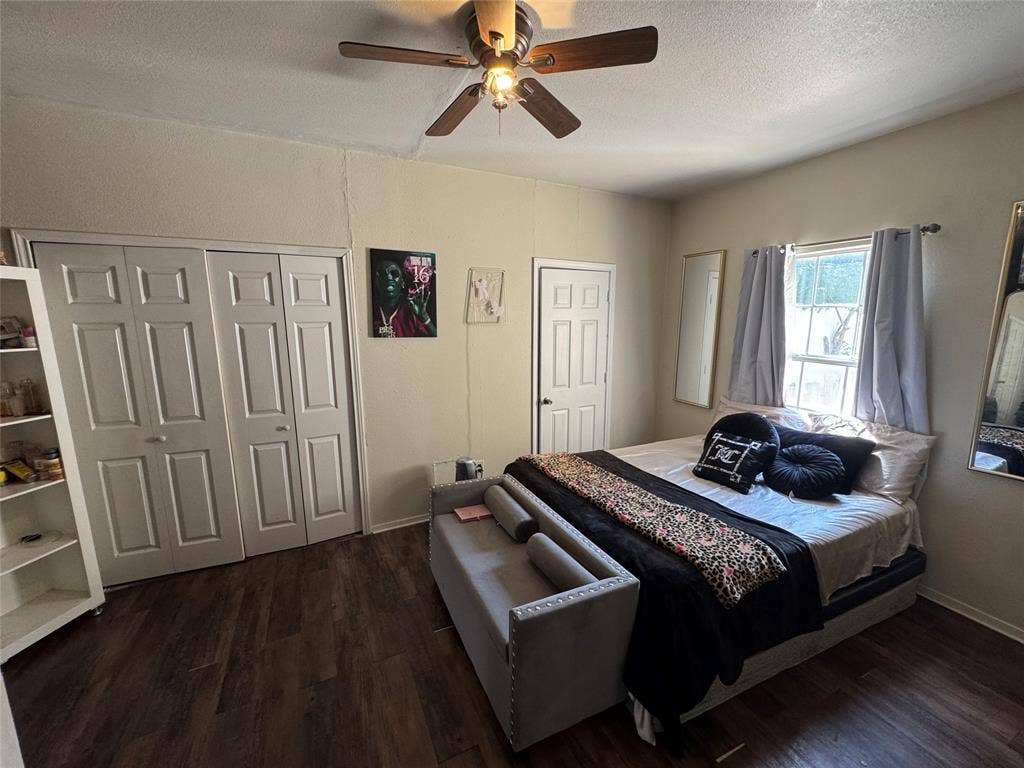 407 S Garrett Avenue, Dallas, TX 75223 Bedroom featuring a textured ceiling, dark wood-style flooring, ceiling fan, and a closet