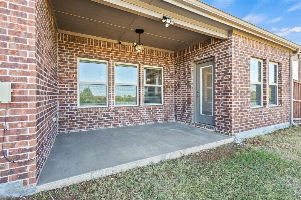 1536 Estivella Drive, Little Elm, TX 75068 Covered concrete patio with brick exterior and multiple windows
