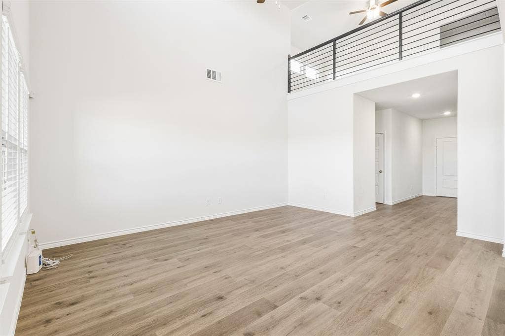 1536 Estivella Drive, Little Elm, TX 75068 Vaulted ceiling, wood-finish flooring, white walls, upper-level railing, and recessed lighting