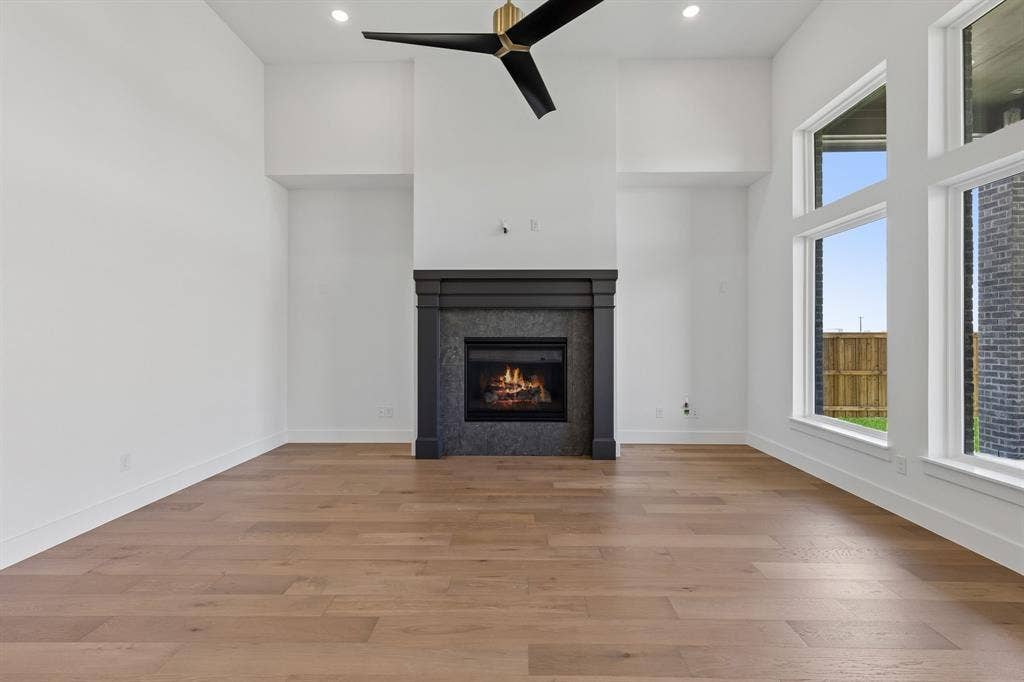 Featuring beautiful flooring with a striking dark fireplace set against neutral colored walls, this over the top family room is the perfect place for memories to be made!
