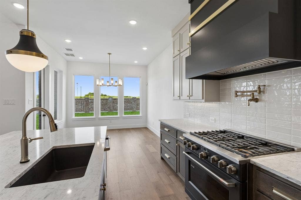 Beautiful two tone cabinetry, gorgeous counter tops and classic backsplash effortlessly pair with high end appliances to create a dream kitchen for the ages!
