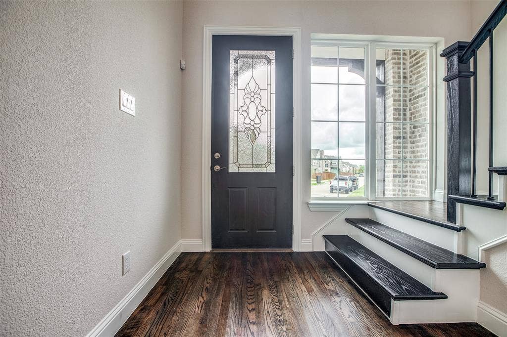 4944 Mckinney Hollow Drive, McKinney, TX 75070 Dark wood-finish flooring, entry door with decorative glass inlay, and a multi-pane window