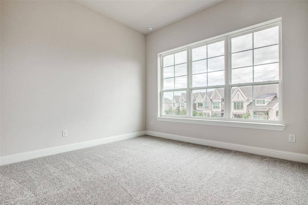 4944 Mckinney Hollow Drive, McKinney, TX 75070 Recessed lighting, large multi-pane window, white window trim, gray wall-to-wall carpeting, and neutral wall paint