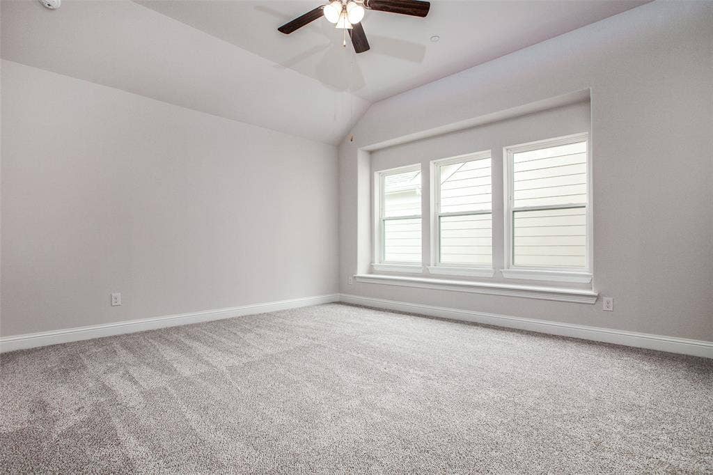 4944 Mckinney Hollow Drive, McKinney, TX 75070 Vaulted ceiling with a ceiling fan, light-toned walls, gray-toned carpet, and a triple window
