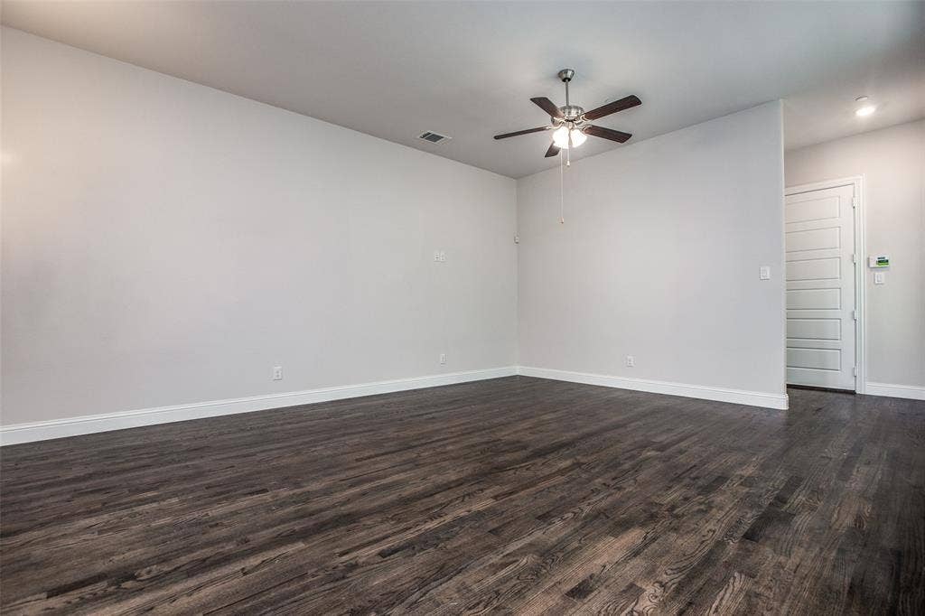 4944 Mckinney Hollow Drive, McKinney, TX 75070 Spacious room featuring wood-finish flooring, light gray wall paint, and a ceiling fan with integrated lighting