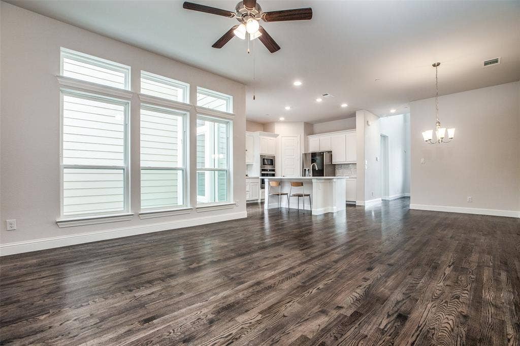 4944 Mckinney Hollow Drive, McKinney, TX 75070 Expansive wood-finish flooring throughout, featuring a wall of multi-pane windows with white trim