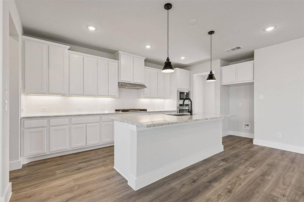 410 Rancher Trail, Waxahachie, TX 75165 Kitchen featuring a central island with countertop, white cabinetry, wood-finish flooring, recessed lighting, and pendant light fixtures