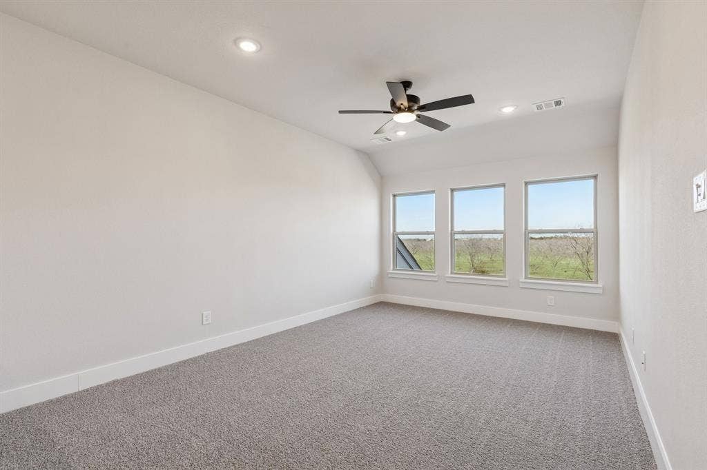 410 Rancher Trail, Waxahachie, TX 75165 Recessed lighting, ceiling fan, three large windows, light gray carpeting, and neutral wall tones