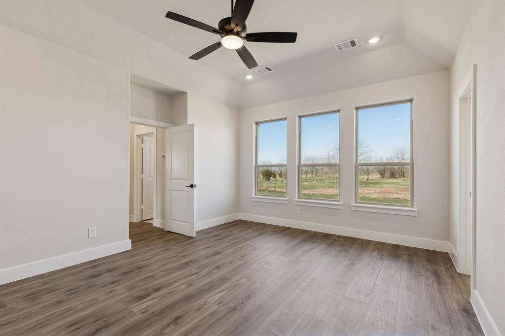 410 Rancher Trail, Waxahachie, TX 75165 Wood-finish flooring, recessed lighting, ceiling fan, vaulted ceiling, and three large windows