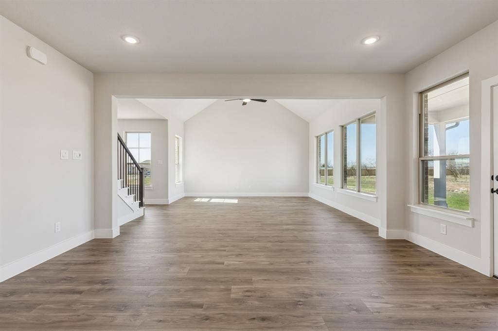 410 Rancher Trail, Waxahachie, TX 75165 Spacious living area featuring wood-finish flooring, recessed lighting, expansive windows, and a vaulted ceiling