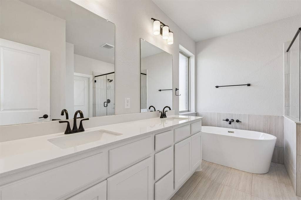 410 Rancher Trail, Waxahachie, TX 75165 Dual vanity with undermount sinks, white cabinetry, and matte black fixtures