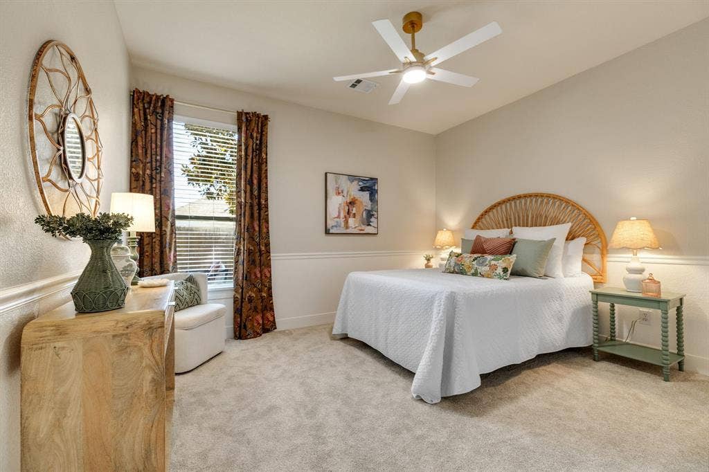 630 Candlewood Trail, Murphy, TX 75094 Neutral tone wall color, window with blinds and drapes, chair rail molding, ceiling fan with light fixture, and light-colored carpeting