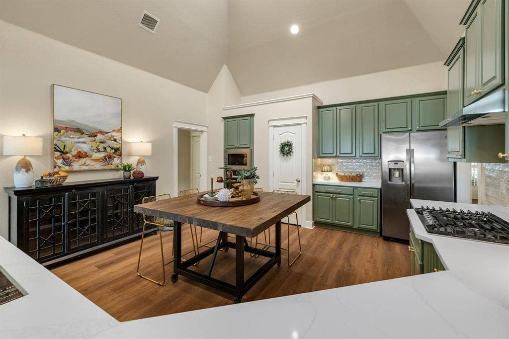 630 Candlewood Trail, Murphy, TX 75094 Vaulted ceilings, wood-finish flooring, white countertops, built-in stainless steel appliances, and green cabinetry