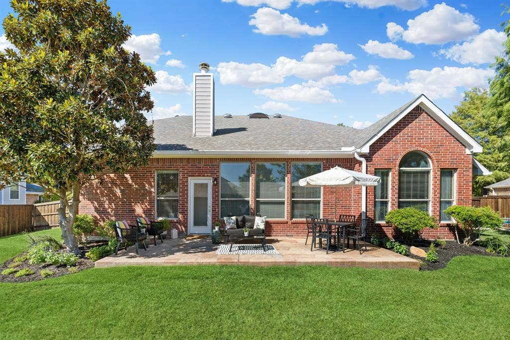 630 Candlewood Trail, Murphy, TX 75094 Brick exterior, expansive lawn, paved patio, mature landscaping, and multiple large windows