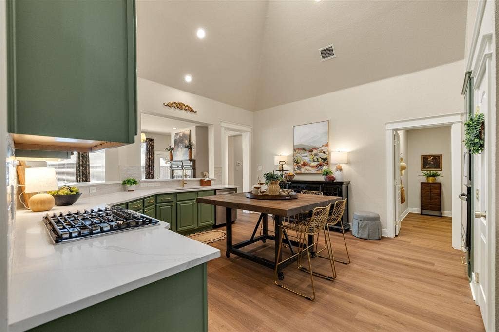 630 Candlewood Trail, Murphy, TX 75094 Gourmet kitchen featuring a gas range, green cabinetry, white countertops, wood-finish flooring, and a vaulted ceiling