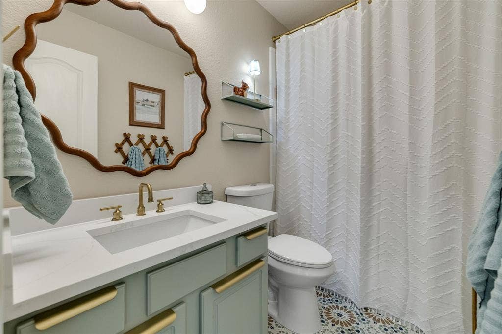 630 Candlewood Trail, Murphy, TX 75094 White vanity countertop with an integrated rectangular sink and brass-finish faucet