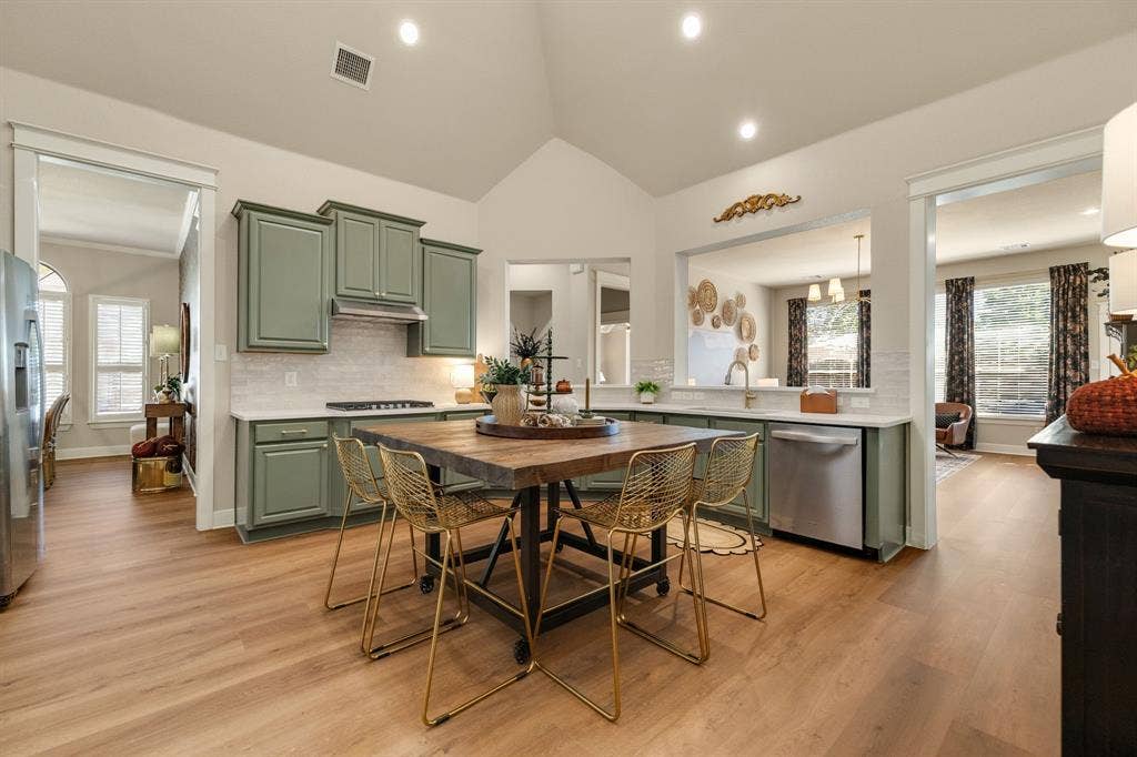 630 Candlewood Trail, Murphy, TX 75094 Kitchen featuring vaulted ceilings, wood-finish flooring, recessed lighting, sage-colored cabinetry, and stainless steel appliances