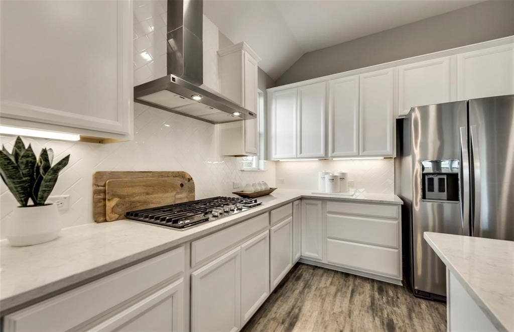 2816 southampton Drive, McKinney, TX 75071 White shaker-style cabinetry with under-cabinet lighting, stainless steel appliances, a built-in gas range with a stainless steel range hood, stone countertops, and wood-finish flooring