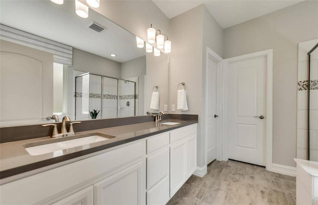 2816 southampton Drive, McKinney, TX 75071 Dual vanity with undermount sinks, extended countertop, and bright overhead lighting