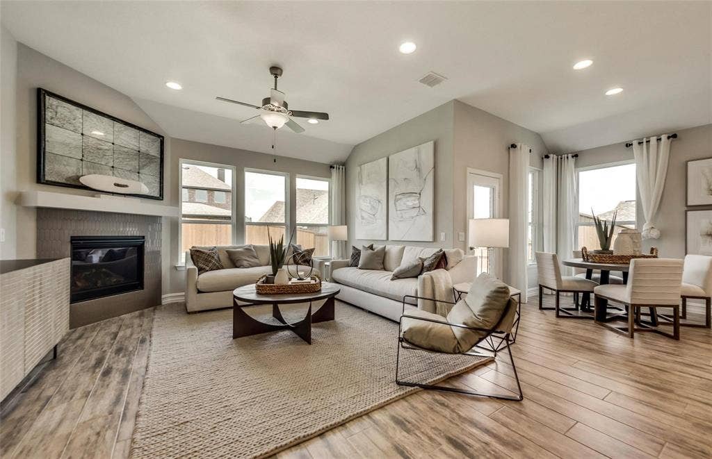2816 southampton Drive, McKinney, TX 75071 Open-concept living area with wood-finish flooring, a fireplace, vaulted ceilings, recessed lighting, and a ceiling fan