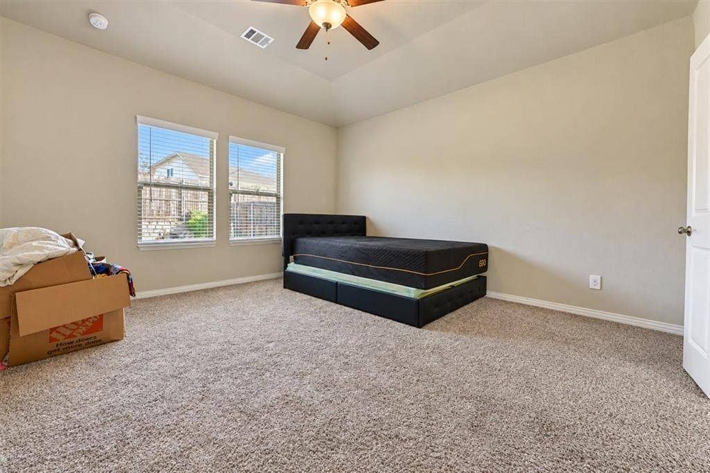 Two windows with blinds, neutral-toned walls, and a ceiling fan with integrated lighting