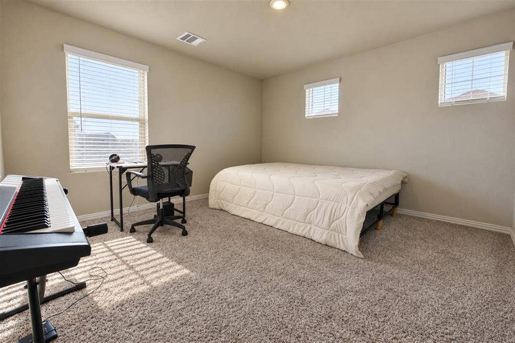 Carpeted room featuring multiple windows, recessed ceiling lighting, and neutral wall tones