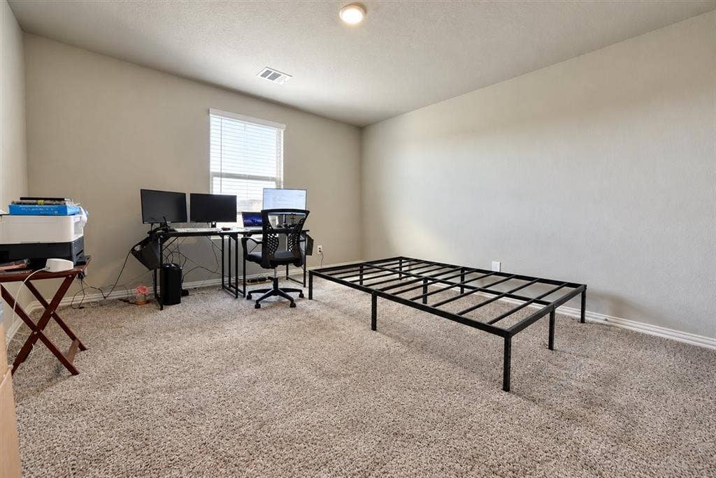 Carpeted room with a single window, white window blinds, and overhead lighting