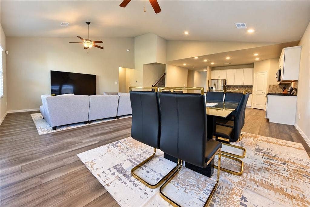 Vaulted ceilings, wood-finish flooring, recessed lighting, and ceiling fans