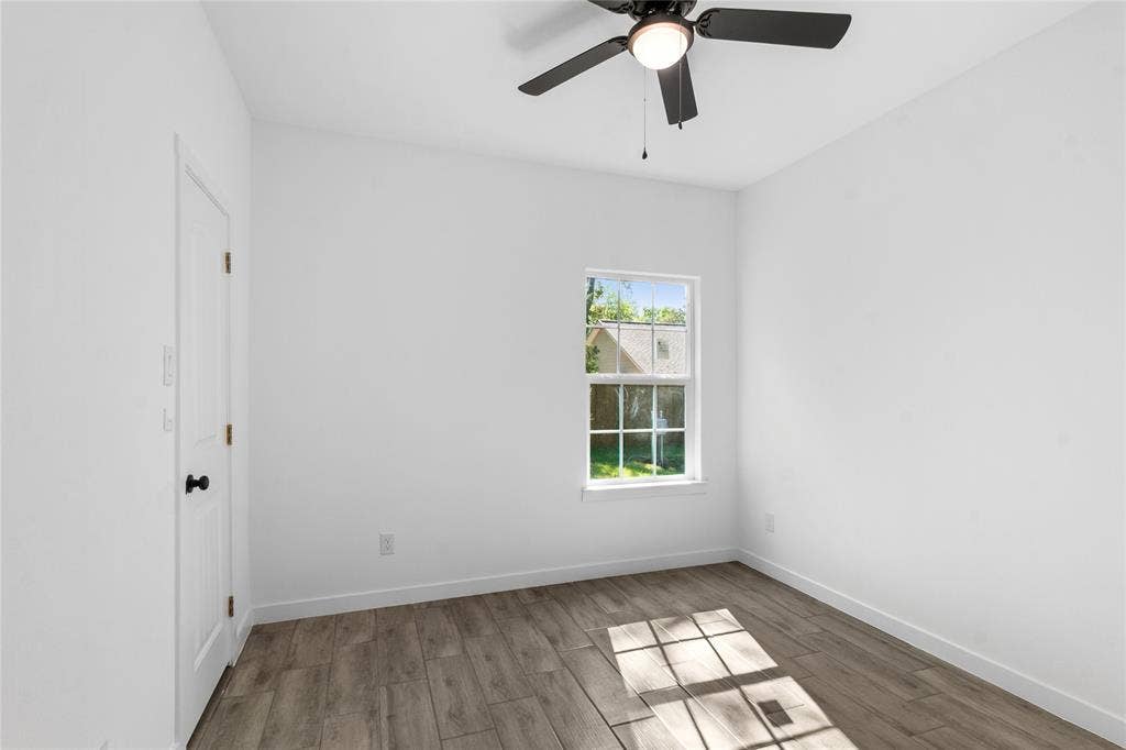 7520 Double Bridge Road, Mabank, TX 75156 Wood-finish flooring with white baseboards, single window, and a ceiling fan with integrated lighting