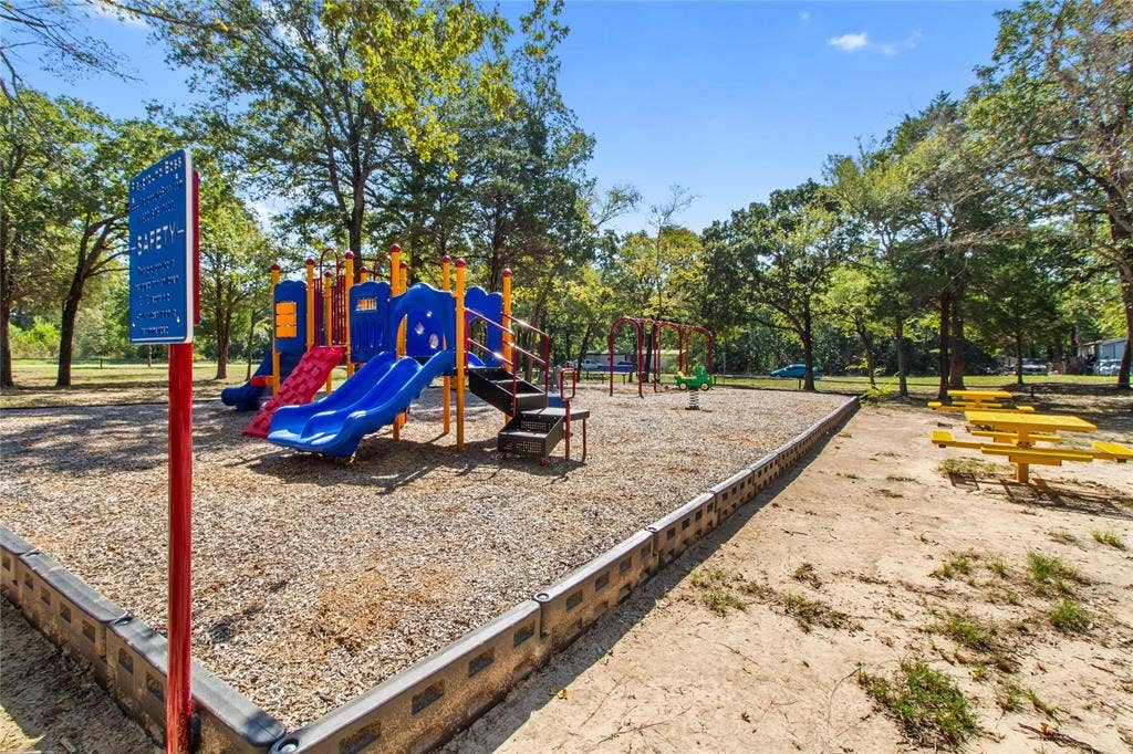 7520 Double Bridge Road, Mabank, TX 75156 Playground area featuring multiple slides, swings, and a spring rider