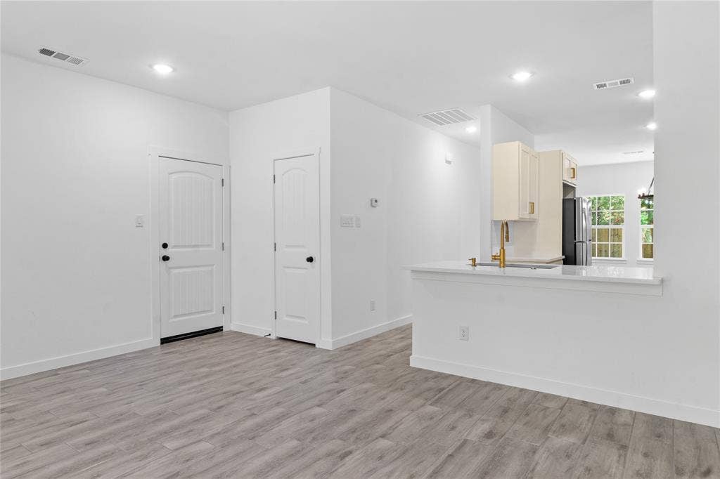 7520 Double Bridge Road, Mabank, TX 75156 Open-concept design featuring wood-finish flooring, recessed lighting, and a kitchen pass-through with a light-toned countertop