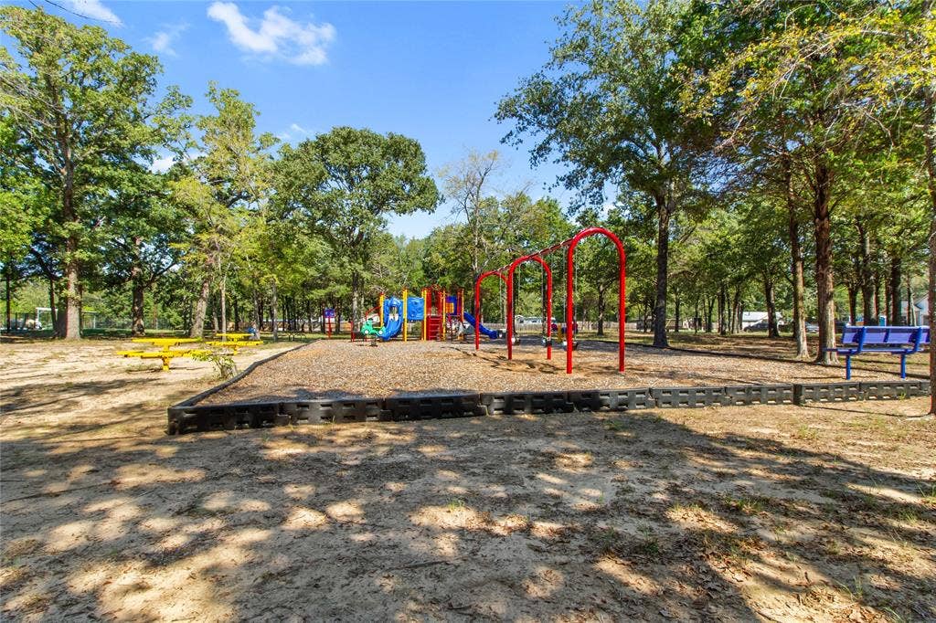 7520 Double Bridge Road, Mabank, TX 75156 Outdoor recreation area featuring a playground with swings and slides, multiple picnic tables, and shaded seating