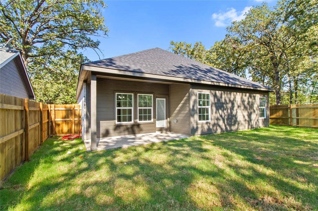 7520 Double Bridge Road, Mabank, TX 75156 Backyard featuring a covered patio, multiple windows, and wood fencing