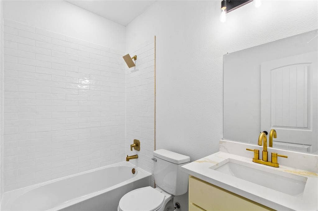7520 Double Bridge Road, Mabank, TX 75156 White subway tile tub surround featuring a gold-finish shower head and controls