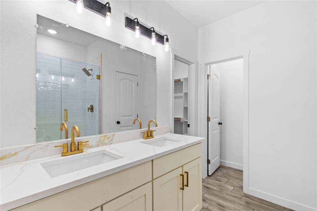 7520 Double Bridge Road, Mabank, TX 75156 Dual vanity with gold-tone fixtures and integrated sinks, complemented by a quartz-finish countertop