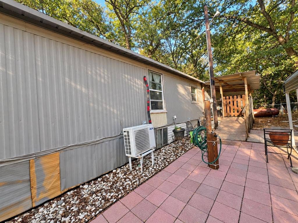 632 Cumberland Trail, Valley View, TX 76272 Patio area with red paver flooring, shaded porch with wooden fencing, and gravel landscaping